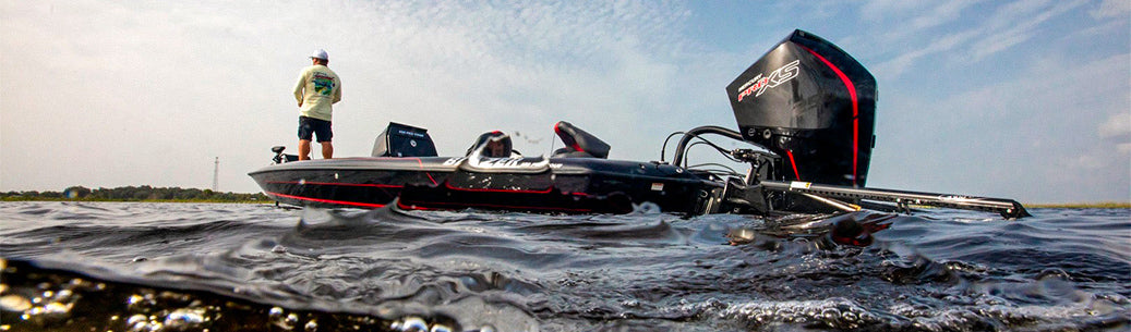 An angler casting from a boat on a misty lake